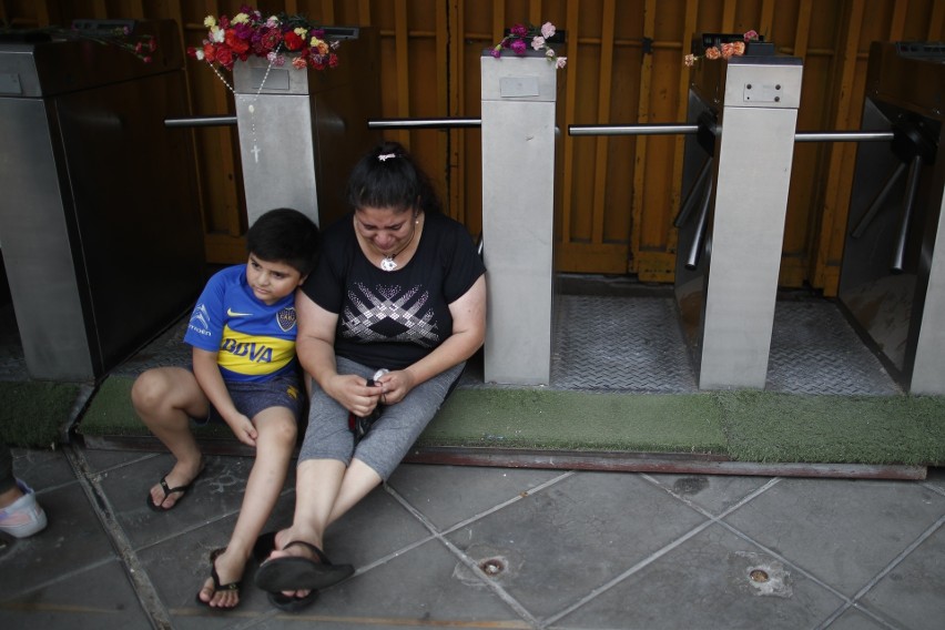 Matka z dzieckiem opłakują Diego Maradonę w bramie stadionu...