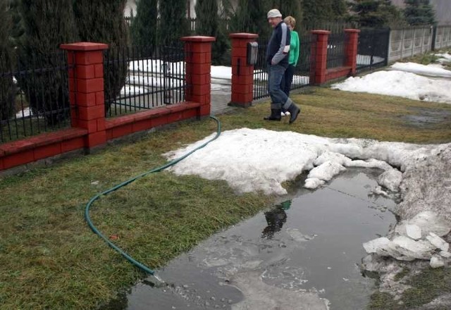 Marian Czech wylewa wodę z podpiwniczenia i przepompowuje ją do pobliskiego rowu. Przyznaje, że to "robota głupiego&#8221;, bo w wypełnionych rowach woda stoi i za jakiś czas znów wszystko ścieka do piwnicy.