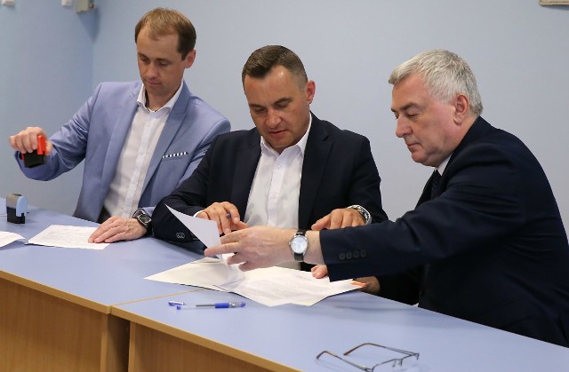 Burmistrz Włoszczowy Grzegorz Dziubek i skarbnik Dariusz Górski podpisują umowę na dofinansowanie z wicewojewodą Andrzejem Bętkowskim.