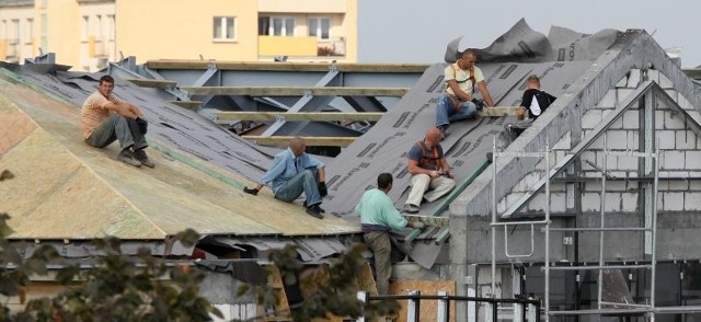 Budowlańcy pracują na dachu bez żadnych zabezpieczeń.