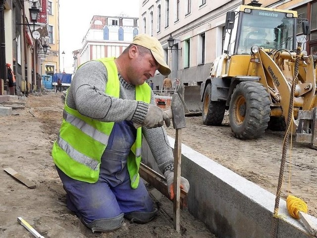 - Praca do lekkich nie należy, ale ważne, że jest - mówi Adam Wiśniewski, pracownik robót drogowych, zatrudniony przez Prasbet, ustawiając krawężniki na ul. Pańskiej.