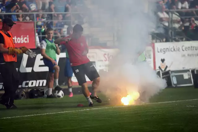 Legnicka policja stara się ustalić, kto odpalił race i rzucał je na murawę podczas derbowego meczu Miedź - Zagłębie Lubin.Kibice Miedzi Legnica i Zagłębia Lubin nie przepadają za sobą. Nic więc dziwnego, że legnicka policja została w niedzielę postawiona na nogi. Do poważnych incydentów poza stadionem nie doszło.Gorzej było już podczas spotkania. Kibice obu drużyn odpalili race. Przyjezdni zaczęli rzucać nimi na murawę. Pseudokibice Miedzi podpalili szaliki i koszulki w barwach Zagłębia. W ruch poszły gaśnice. Wśród miejscowych fanów sporo było osób w barwach Śląska Wrocław. Obie grupy sympatyzują bowiem ze sobą.Jak poinformowała nas mł. asp. Jagoda Ekiert, oficer prasowa Komendy Miejskiej Policji w Legnicy, nikt po meczu nie został jednak zatrzymany. - Policja zabezpieczyła nagrania video ze stadionowego monitoringu. Będziemy chcieli ustalić, kto odpalił race - poinformowała nas.Oczywiście nie będzie to takie łatwe, bo pseudokibice zakładają kominiarki, przez co trudniej jest ich zidentyfikować.Z całą pewnością Miedź zostanie ukarana finansowo przez Polski Związek Piłki Nożnej. W skrajnym przypadku policja może złożyć wniosek do wojewody dolnośląskiego o zamknięcie na pewien czas całego stadionu, bądź jednej trybuny. Na razie jednak za wcześnie, by o tym mówić.Trzeba jednak przyznać, że mimo tych incydentów, widowisko w Legnicy się udało. Oczywiście zadowoleni po spotkaniu byli tylko miejscowi. Piłkarze Zagłębia Lubin musieli się natomiast tłumaczyć przed swoimi kibicami.Teraz obie drużyny czeka przerwa związana z meczami reprezentacji Polski. Po niej Zagłębie podejmie u siebie Śląska Wrocław, a Miedź pojedzie na mecz z Wisłą Płock.DO KOLEJNYCH ZDJĘĆ MOŻNA PRZEJŚĆ ZA POMOCĄ STRZAŁEK