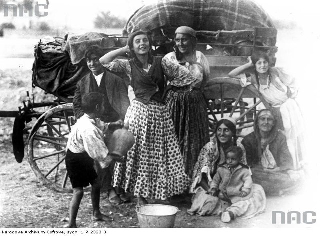 Rodzina cygańska na tle tradycyjnego wozu.