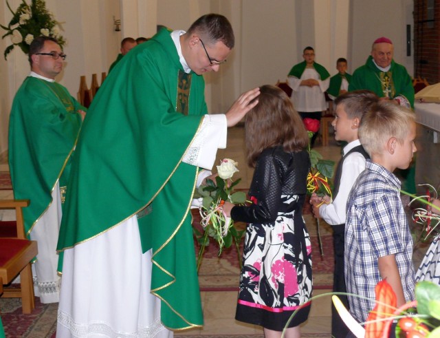 Ksiądz Mateusz żegnany kwiatami przez dzieci na Mszy świętej, na uroczystości posłania na misje.