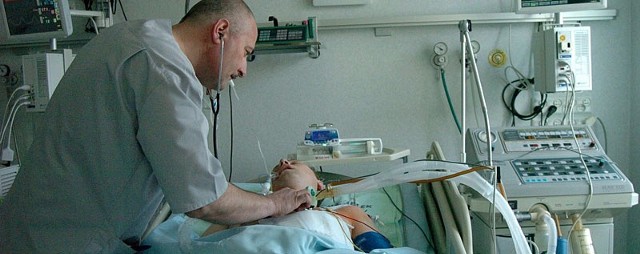 Grzegorz Litwicki, ordynator OIOM szpitala w Jaśle pochyla się nad pacjentem. Zdjęcie zrobiliśmy w piątek, tuż po operacji. Od soboty pan Stanisław jest przytomny i sam oddycha. 