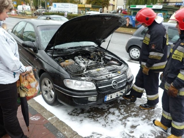Strażacy sprawdzają, czy samochód jest już bezpieczny.