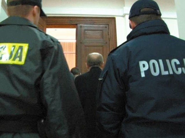 Mirosław C. w asyście policjantów wchodzi do sali sądowej 
