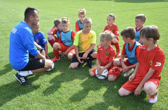 Odwiedziliśmy na treningach niektóre grupy młodych piłkarzy i futbolistek KKP Korona Kielce. Byliśmy na zajęciach prowadzonych między innymi przez trenerów Michała Kostuchę, Michała Stachurę oraz Marię Tarczyńską i Marlenę Kasprzyk, które prowadzą zajęcia w Żółto-czerwonym przedszkolu. Zachęcamy do obejrzenia galerii zdjęć. Szczegóły na kolejnych slajdach.(dor)