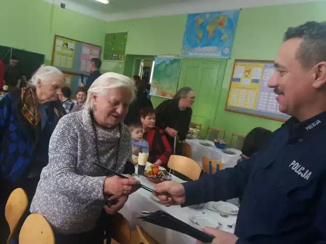 Podczas spotkania w szkole w Borowem w gminie Mogielnica mundurowi rozdali seniorom opaski odblaskowe.