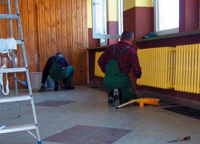 Więźniowie remontują korytarz w zespole szkół