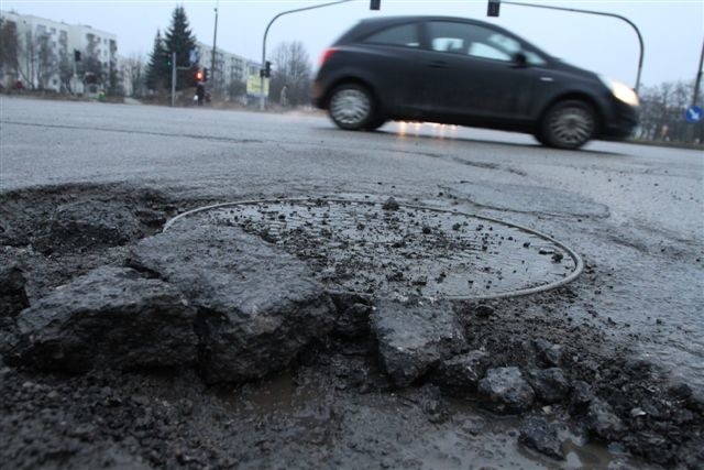 Gigantyczna i bardzo niebezpieczna dziura na skrzyżowaniu ulicy Warszawskiej z Jesionową. Z jej otchłani wystają olbrzymie kawałki skruszonego asfaltu.