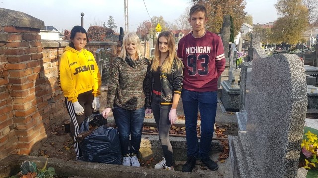 Uczniowie z Nowej Wsi wraz z opiekunką samorządu uczniowskiego podczas porządkowania grobów.