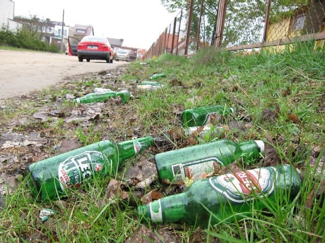 Wokół ogrodzenia sklepu, oprócz butelek po piwie, ludzie zostawiają też worki pełne domowych  odpadów. Teren należy do miasta.