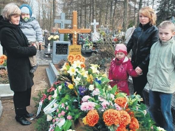 Na cmentarzu w Budowie przy grobie pani Iwony stoją:...