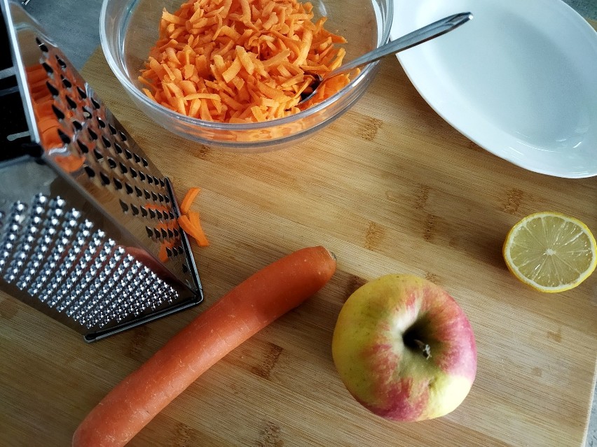 Zetrzyj marchewki i jabłko na tarce lub drobno pokrój.