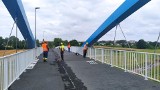 Kładka przez Kanał Ulgi w Opolu jest prawie gotowa. Robotnicy układają na niej asfalt, potem czas na odbiory i będzie można z niej korzystać