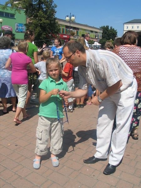 Uczestnikom pikniku wręczano smycze, na których znajdują się najważniejsze telefony alarmowe. Na zdjęciu Piotr Wałcerz, prezes stowarzyszenia "Bezpieczne Miasto