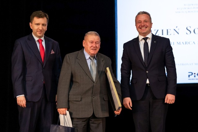 Nagrodę z wiele lat pracy odebrał m.in. Konrad Cichański, sołtys Osielska. Po lewej minister Łukasz Schreiber, po prawej wojewoda Mikołaj Bogdanowicz.