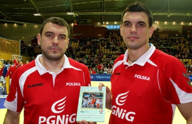 Bracia Bartek i Michał Jureccy  zawodnicy polskiej reprezentacji w piłce ręcznej z książką przekazaną na aukcję internetową.