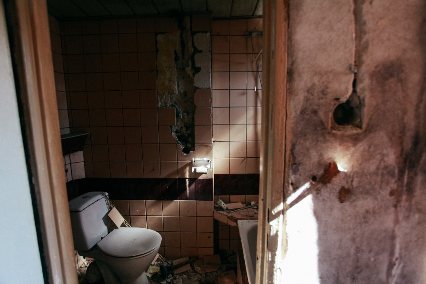 Zdewastowana toaleta w tak samo zdewastowanych barakach, z...