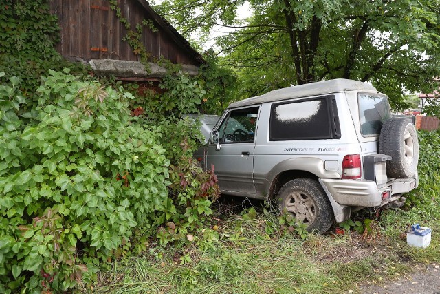 Miejsce zdarzenia, widać auto, które zatrzymało się po uderzeniu w ścianę drewnianego domu