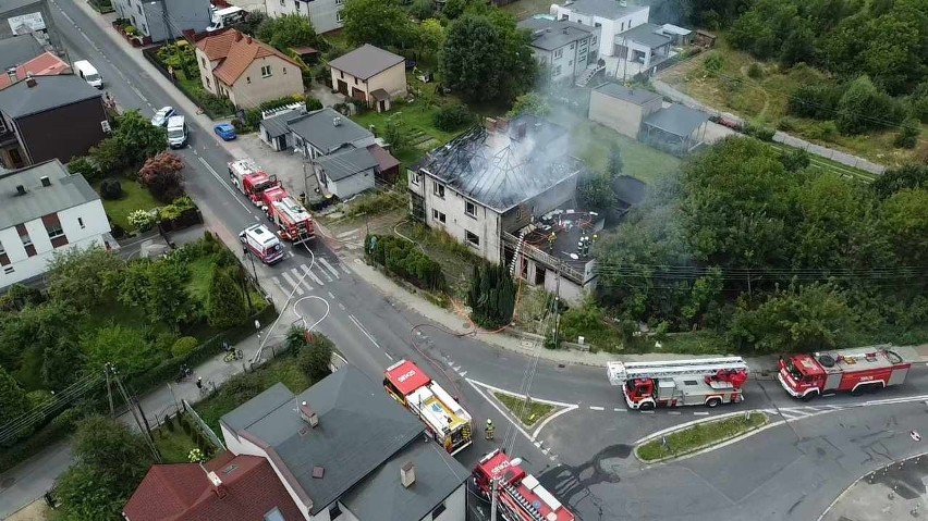 Strażacy walczą z ogniem, który objął dach budynku