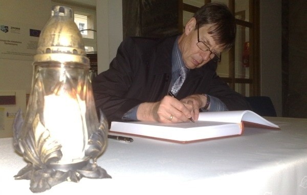 Ryszard Zembaczyński wpisuje się do księgi kondolencyjnej.