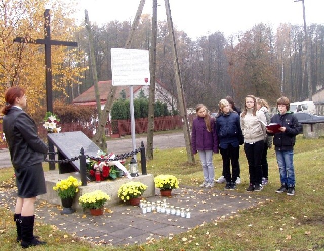 Pod pomnikiem uczniowie recytowali poezję. Z lewej Grażyna Janisiak &#8211; Wiśnioch,  dyrektorka szkoły w Młodocinie Mniejszym