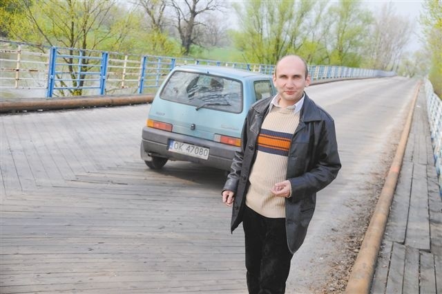 Krzysztof Siemaszko z Powiatowego Zarządu Dróg podkreśla, że drewniana nawierzchnia zbyt szybko się niszczy, gdy na moście pojawiają się ciężarówki, bądź duży sprzęt rolniczy. (fot. Daniel Polak)