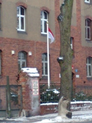 Odwrócona flaga przed budynkiem żandarmerii wojskowej.