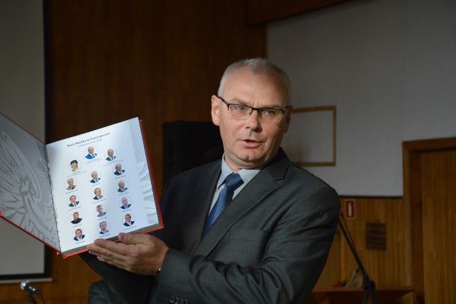 Przewodniczący Krzysztof Wojtusik pokazuje prezent, jaki na zakończenie kadencji otrzymali wszyscy radni