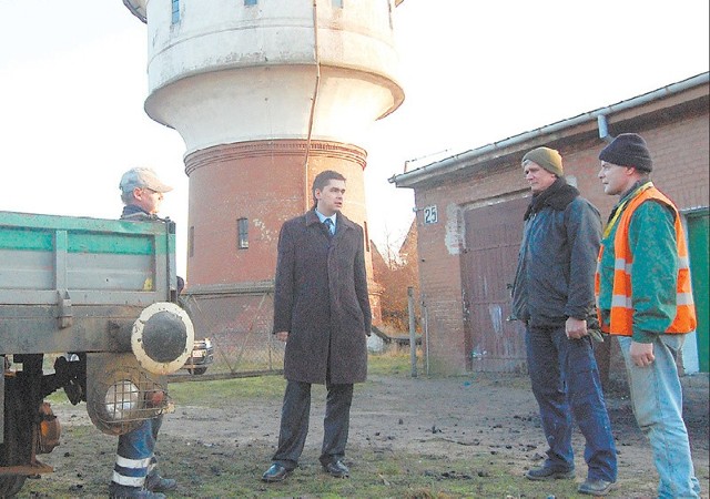 Burmistrz Michał Hypki (w środku) rozmawia z pracownikami Polskich Linii Kolejowych o pomyśle zorganizowania turystyki drezynowej. W tle budynek nieczynnej wieży ciśnień, którą gmina chciałaby przejąć od kolei.