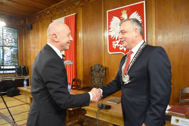 Daniel Rak jest już oficjalnie nowym burmistrzem Szczecinka. Na pierwszej sesji na przewodniczącą Rady Miasta wybrano także Katarzynę Dudź. W środę w szczecineckim ratuszu na inauguracyjnej sesji zebrała się nowa Rady Miasta. Radni odebrali zaświadczenia o wyborze i złożyli ślubowanie. Wybrali także przewodniczącego. Platforma Obywatelska ma samodzielną większość, więc była tylko jedna kandydatura – Katarzyny Dudź, dotychczasowej przewodniczącej RM. Głosowało na nią 14 radnych, nikt nie był przeciw, a 5 osób się wstrzymało od głosu. Co oznacza, że przynajmniej część radnych opozycji poparło ten wybór. Przypomnijmy, że PO ma 13 radnych, Prawo i Sprawiedliwość 5, a Porozumienie Samorządowe troje. Następnie ślubowanie złożył Daniel Rak, burmistrz wybrany 4 listopada przez mieszkańców Szczecinka, obejmując tym samym oficjalne rządy w ratuszu. Symbolicznie miejsca ustąpił mu na fotelu burmistrza ustępujący z urzędu Jerzy Hardie-Douglas, którego zastępcą przez 13 lat rządów był właśnie Daniel Rak. I on też zdjął z szyi łańcuch burmistrzowski i założył go swojemu następcy. Obaj panowie reprezentują Platformę Obywatelską. Były burmistrz jest teraz radnym powiatowym, co ciekawe po raz pierwszy od 12 lat, bo w starostwie partnerem koalicyjnym Porozumienia Samorządowego został PiS. Kolejna sesja Rady Miasta już w przyszłym tygodniu. Wybrany na niej zostanie skład prezydium i komisji problemowych, a burmistrz Daniel Rak wygłosi swoje expose przedstawiając plan działań na najbliższy rok i całą kadencję 2018-2023. Część z nich znamy już z obietnic składanych w kampanii wyborczej, ale nie wszystkie znalazły się w projekcie budżetu Szczecinka na rok 2019, który de facto przygotowywał jeszcze poprzednik. Jerzy Hardie-Douglas uwzględnił w nim jednak kilka sztandarowych pomysłów swego zastępcy – jest 300 tysięcy złotych na becikowe, czyli po 1000 zł dla rodziców każdego nowonarodzonego mieszkańca Szczecinka i 800 tys. zł na budżet obywatelski. Darmowe bilety Komunikacji Miejskiej miały być wprowadzone w pierwszym, autorskim budżecie Daniela Raka, a więc zapewne od 2020 roku.Zobacz także  Szczecinek: Uroczystości z okazji 100-lecia Niepodległości