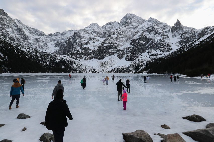 Turyści na tafli lodu na jeziorze Morskie Oko w Tatrach.