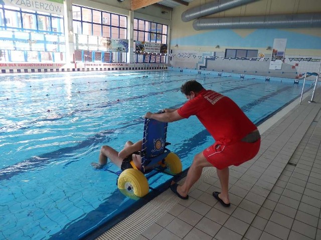 Wózek wraz z osobą niepełnosprawną zanurza się w basenie