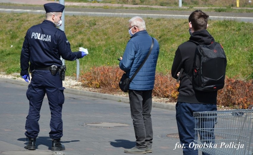 Opolscy policjanci rozdają maseczki na ulicach miasta.