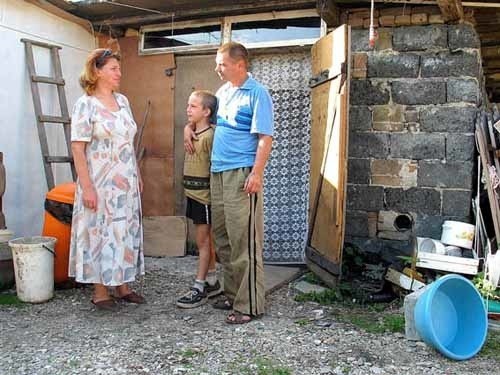 Rodzina Doronimów przed prowizoryczną komórką, która od ponad roku jest ich domem.