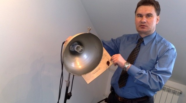 Podinspektor Leszek Dębowski, zastępca komendanta powiatowego policji w Sandomierzu, prezentuje wykorzystywaną przy przesłuchaniach lampę z czasów PRL