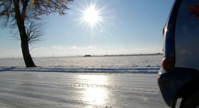 W jezdni skutej lodem odbija się słońce