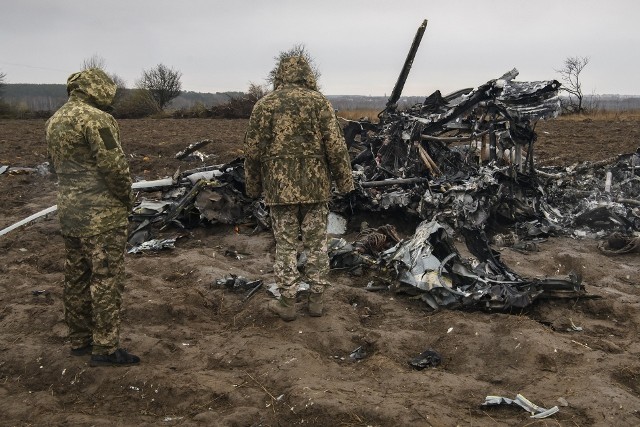 Ukraińscy żołnierze przyglądają się fragmentom rosyjskiego śmigłowca wojskowego Mi-8 zestrzelonego koło Makarowa.