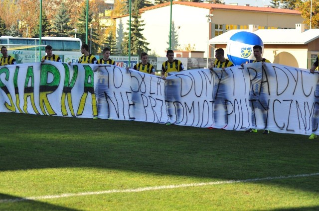 Piłkarze Siarki Tarnobrzeg z transparentem odnoszącym się do bieżącej sytuacji klubu.