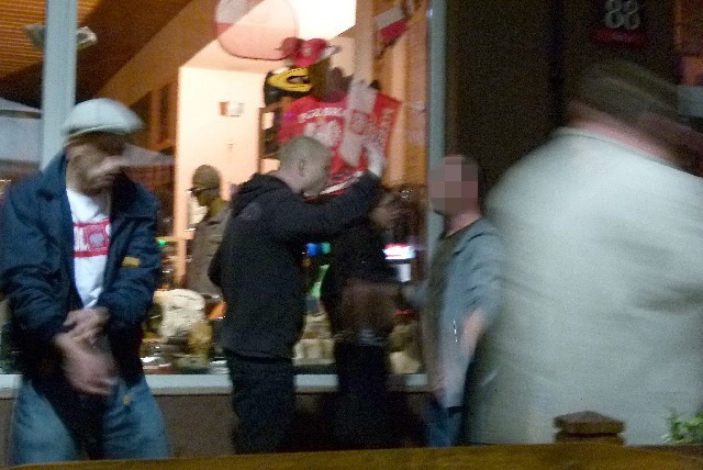 Mężczyzna z prawej stanął w obronie barmanki obrażonej przez człowieka w bluzie z kapturem.