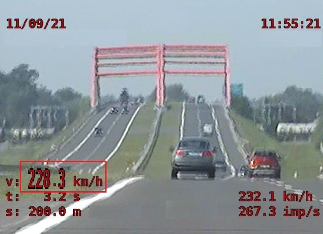 Stopklatka z nagrania z policyjnego wideorejestratora. W czerwonym prostokącie zaznaczona prędkość rejestrowanego bmw