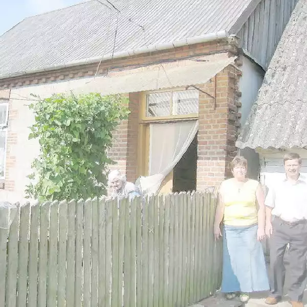 Przed starą, przedwojenną szkołą zbudowaną przez rodzinę Krazińskich we własnym obejściu stoją radni Barbara Prylińska i Sławomir Kraziński. W głębi Marta Krazińska.