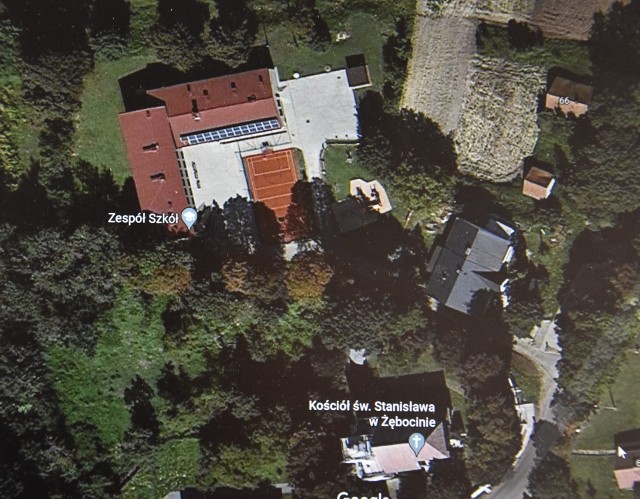 U góry obiekty Zespołu Szkół w Żębocinie, po prawej widoczny dawny dom nauczyciela. Teren, który ma zamiar kupić  gmina, znajduje się w prawym, górnym rogu fotografii. Znajdują się na nim dwa niewielkie budynki.