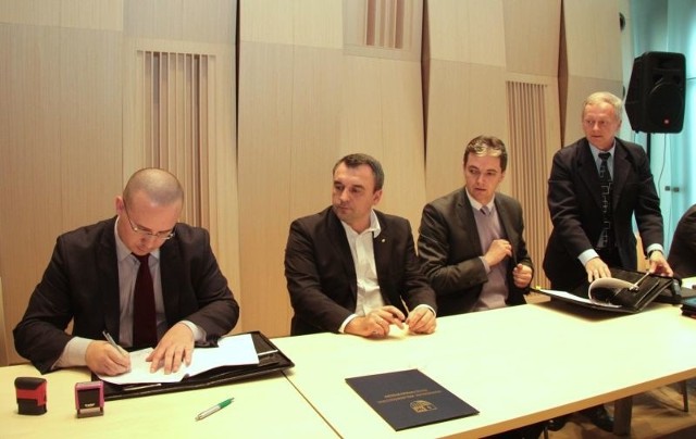 Burmistrz Jędrzejowa Marcin Piszczek podpisuje umowę na modernizację targowiska w mieście.