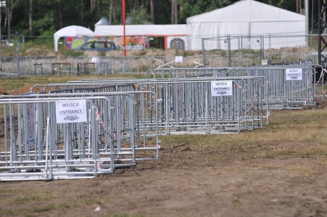 W tym roku uczestników Przystanku Woodstock 2017 może zaskoczyć widok barierek, ustawionych przed Dużą Sceną. Wygradzają one teren, na którym będzie się odbywała impreza masowa. Co to oznacza?Na teren wygrodzony barierkami prowadzi kilka wejść. Będzie tu stała ochrona, która sprawdzi, czy nie wnosicie na wygrodzony teren m. in. piwa. Można się tu spodziewać kontroli plecaków. Ochrona może też sprawdzić wasze kieszenie. To nowość w stosunku do lat poprzednich. Wprawdzie już wcześniej na terenie przed Dużą Sceną oficjalnie obowiązywał zakaz spożywania alkoholu, jednak byli woodstockowicze, którzy go nie egzekwowali.Przeczytaj też:  Owsiak o Woodstocku: My już nie wyrobimy, nie damy rady! To ostatni festiwal w Kostrzynie?Na Przystanku Woodstock 2017 teren wygrodzony barierkami będzie miejsce imprezy masowej. Oznacza to, że będą tu obowiązywały określone zasady. Nie będzie można wnosić alkoholu, ani materiałów pirotechnicznych. Oczywiście obowiązuje tu też zakaz wnoszeni narkotyków i jakiekolwiek broni. Teren przed Dużą i Małą Sceną będzie monitorowany, podobnie jak teren przed sceną w Pokojowej Wiosce Kryszny oraz w dużym namiocie na Akademii Sztuk Przepięknych. Monitoring ma pomóc w ustaleniu ewentualnych osób, które złamią w tych miejscach obowiązujące przepisy.Chcesz wiedzieć kto zagra na Przystanku Woodstock 2017? Przystanek Woodstock 2016: zespoły, koncerty kto zagraCo o barierkach myślą woodstockowicze? - Bzdura! Przecież w poprzednich latach barierek nie było i było bezpiecznie, nikomu nic się nie stało, ludzie swobodnie mogli się przemieszczać. Teraz będą nas wygradzać jak bydło. Nie podoba mi się ten pomysł - mówi Arleta Wilczyńska z Torunia. Takich głosów jest dużo więcej. - Barierki przed Dużą Sceną na Woodstocku to jakieś nieporozumienia. One nie zdadzą tu egzaminu, wprowadzą większe zagrożenie, niż by ich w tym miejscu nie było - uważa Tomek Krukowski z Bytomia Odrzańskiego. - A co, jeśli odpukać pod sceną coś się wydarzy i wszyscy ludzie nagle będą chcieli uciec? W poprzednich latach mogli swobodnie rozbiec się po polu, a teraz? To jest porażka - uważa Adam z okolic Gdańska. Przystanek Woodstock 2017 został uznany za imprezą podwyższonego ryzyka i to m. in. z tego powodu przed Dużą Sceną znajdują się barierki. Komendant Miejski Policji w Gorzowie w swojej opinii na temat bezpieczeństwa festiwalu napisał m. in., że istnieje tu ryzyko zamachów terrorystycznych.Wszystkie informacje o Przystanku Woodstock 2017 w Kostrzynie nad Odrą:  Przystanek Woodstock 2017: koncerty, zdjęcia, filmy, informacje