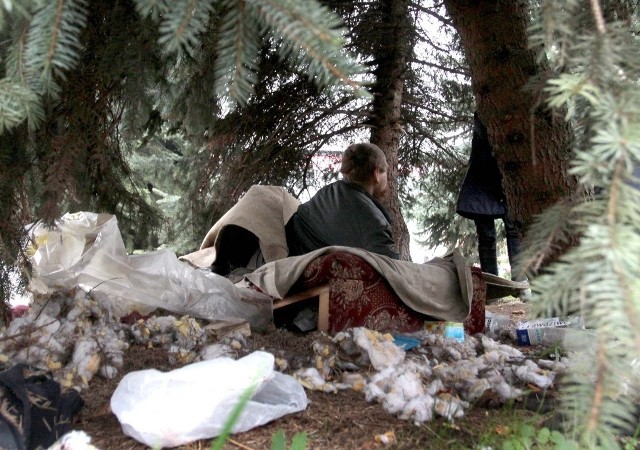 Pan Wiesław nocuje pod drzewem przy Biedronce na Ustroniu. Przykrywa się dywanem.