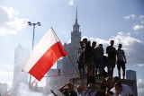 Marsz Powstania Warszawskiego w Warszawie. Na trasie tęczowe flagi. Policja zdejmowała je z balkonów