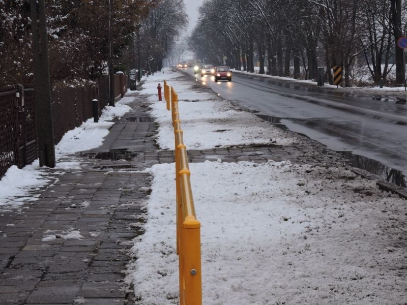 Żółte barierki przy chodniku przy ul. Słowackiego. Niby...